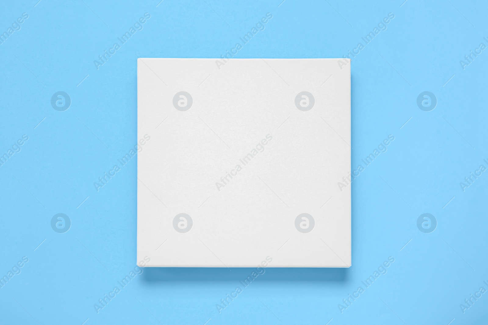 Photo of Blank canvas on light blue background, top view. Space for design