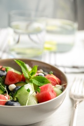 Photo of Delicious salad with watermelon served on white wooden table, closeup