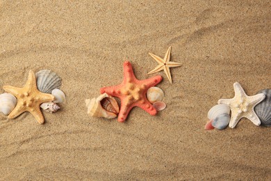 Beautiful sea stars and shells on sand, flat lay