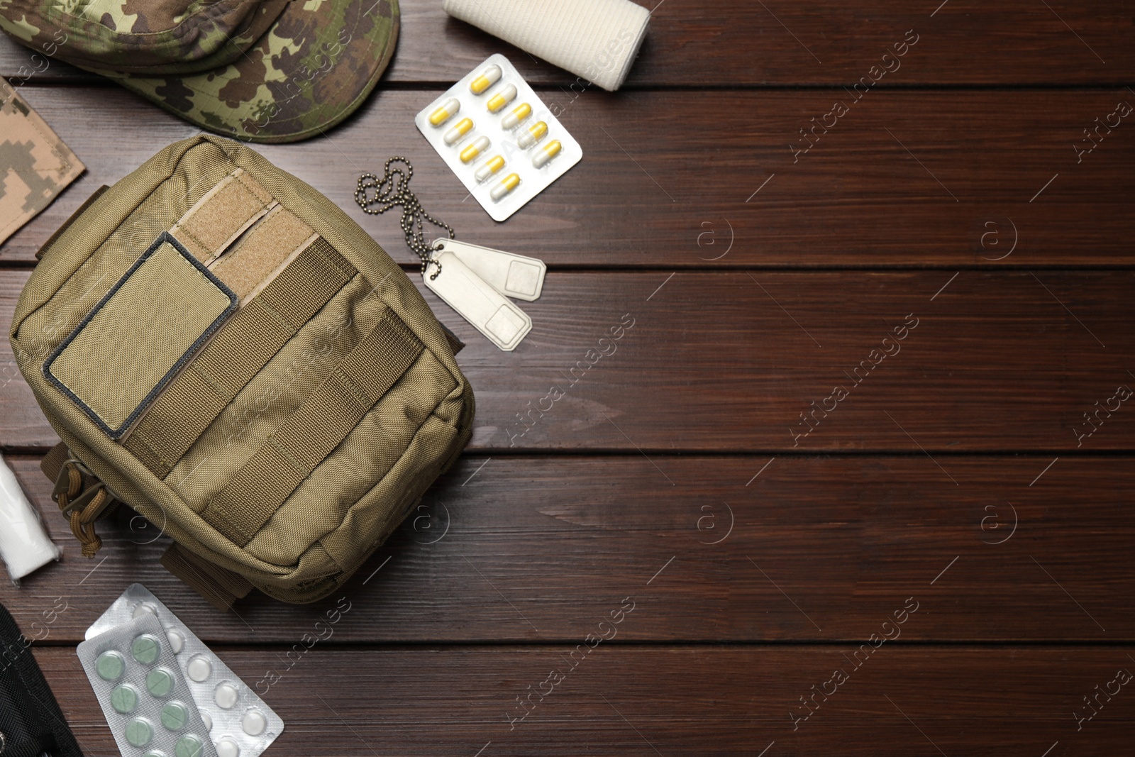 Photo of Military first aid kit on wooden table, flat lay. Space for text