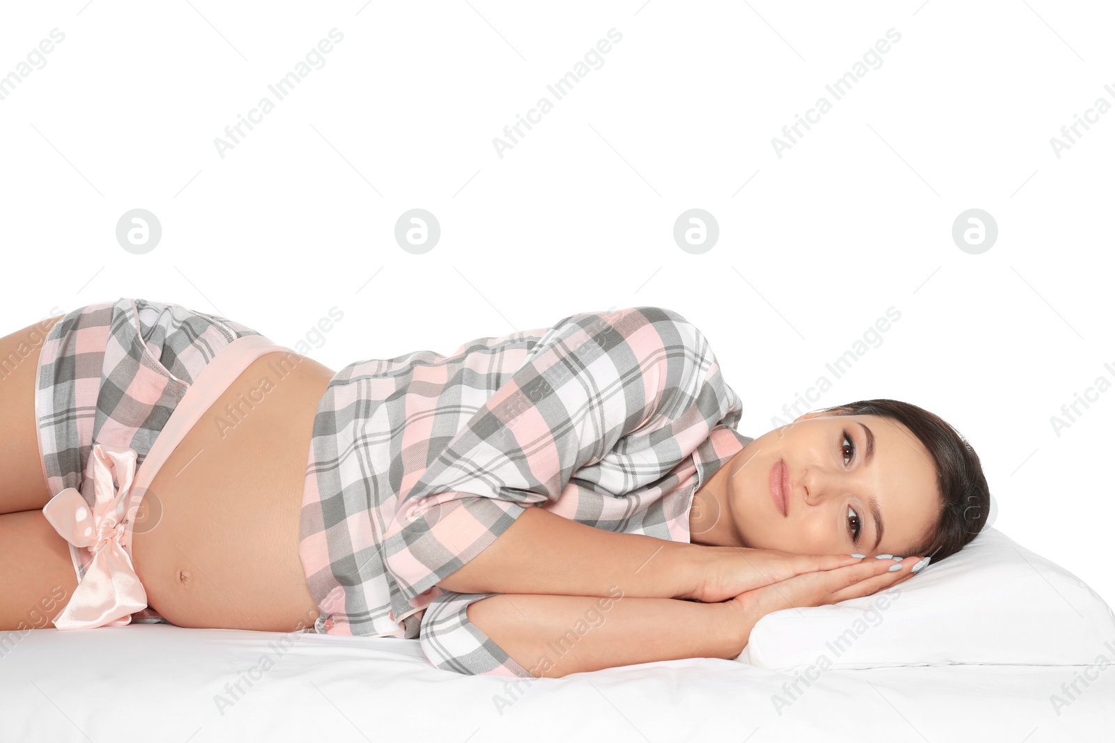 Photo of Beautiful pregnant woman lying with orthopedic pillow on bed against white background