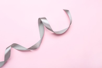 Photo of Beautiful ribbon on pink background, top view. Space for text