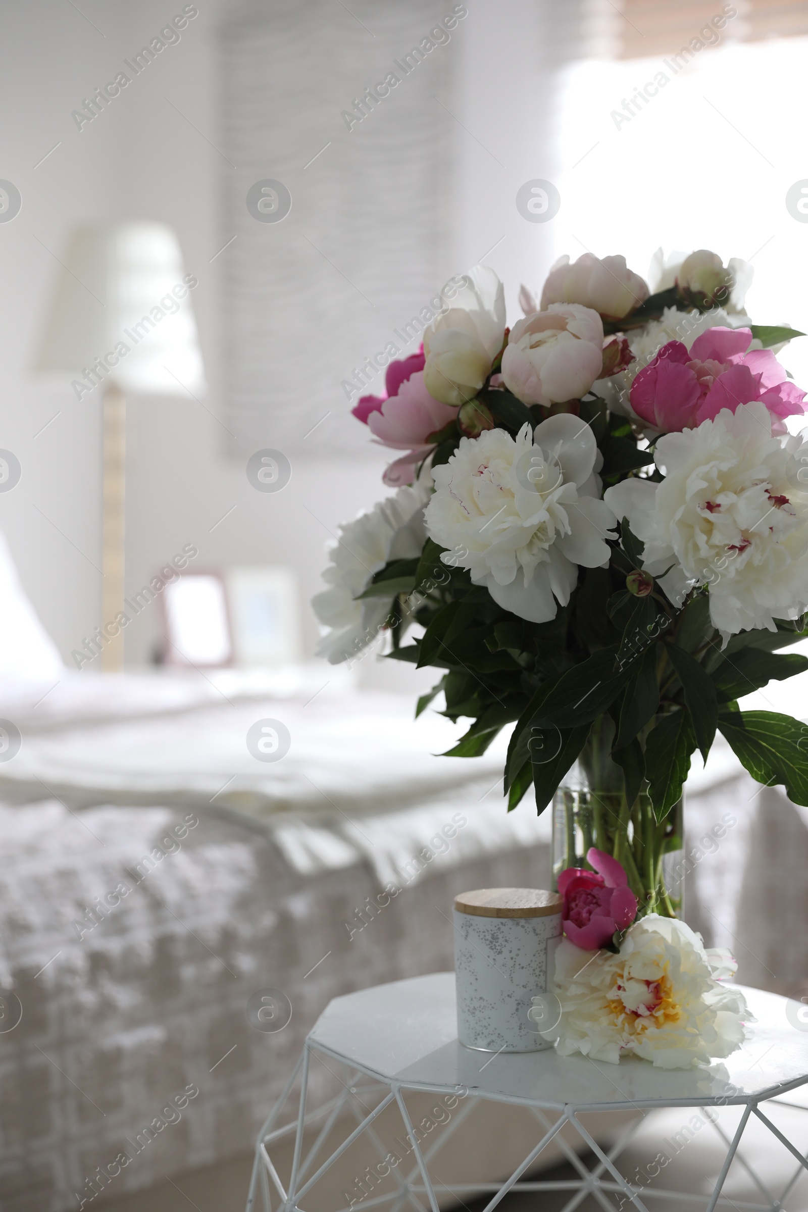 Photo of Beautiful blooming peonies on table in bedroom