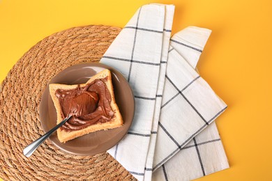 Tasty toast with chocolate paste on yellow background, top view. Space for text