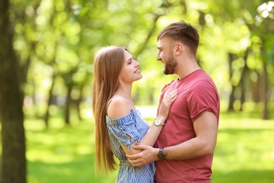 Happy young couple in green park on sunny spring day