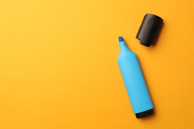 Photo of Bright light blue marker on orange background, flat lay. Space for text