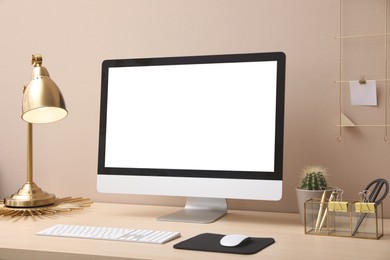 Photo of Stylish workplace with modern computer near beige wall indoors. Space for text