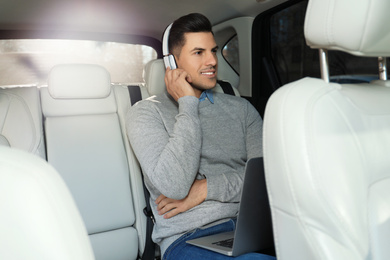 Photo of Handsome man listening to audiobook in car