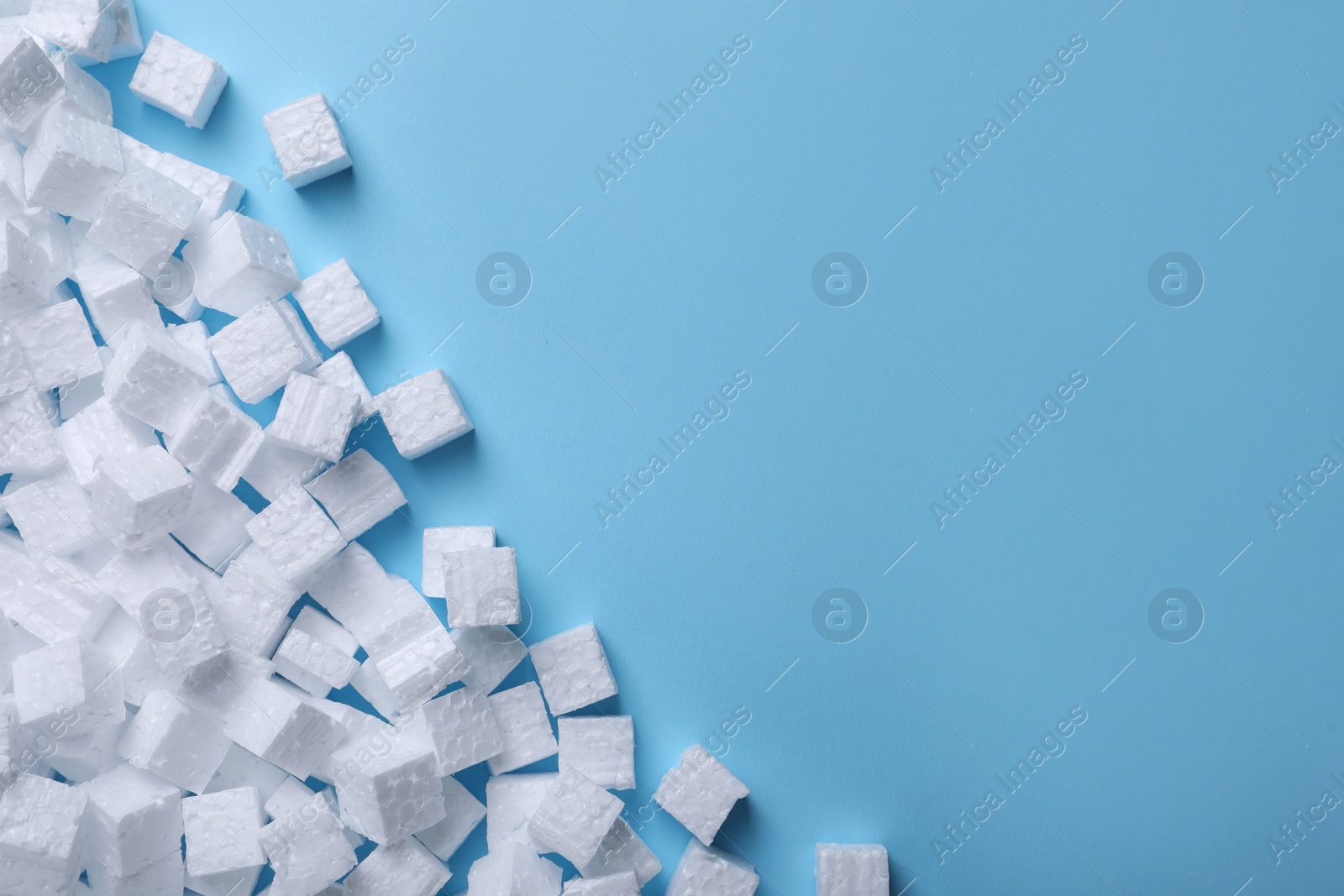 Photo of Many styrofoam cubes on light blue background, flat lay. Space for text