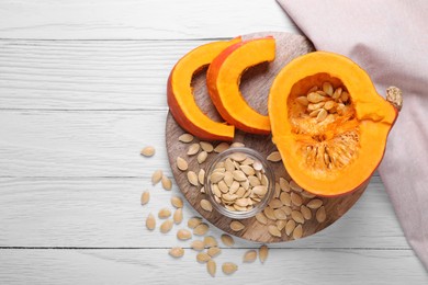 Photo of Fresh pumpkin and vegetable seeds on white wooden table, flat lay. Space for text