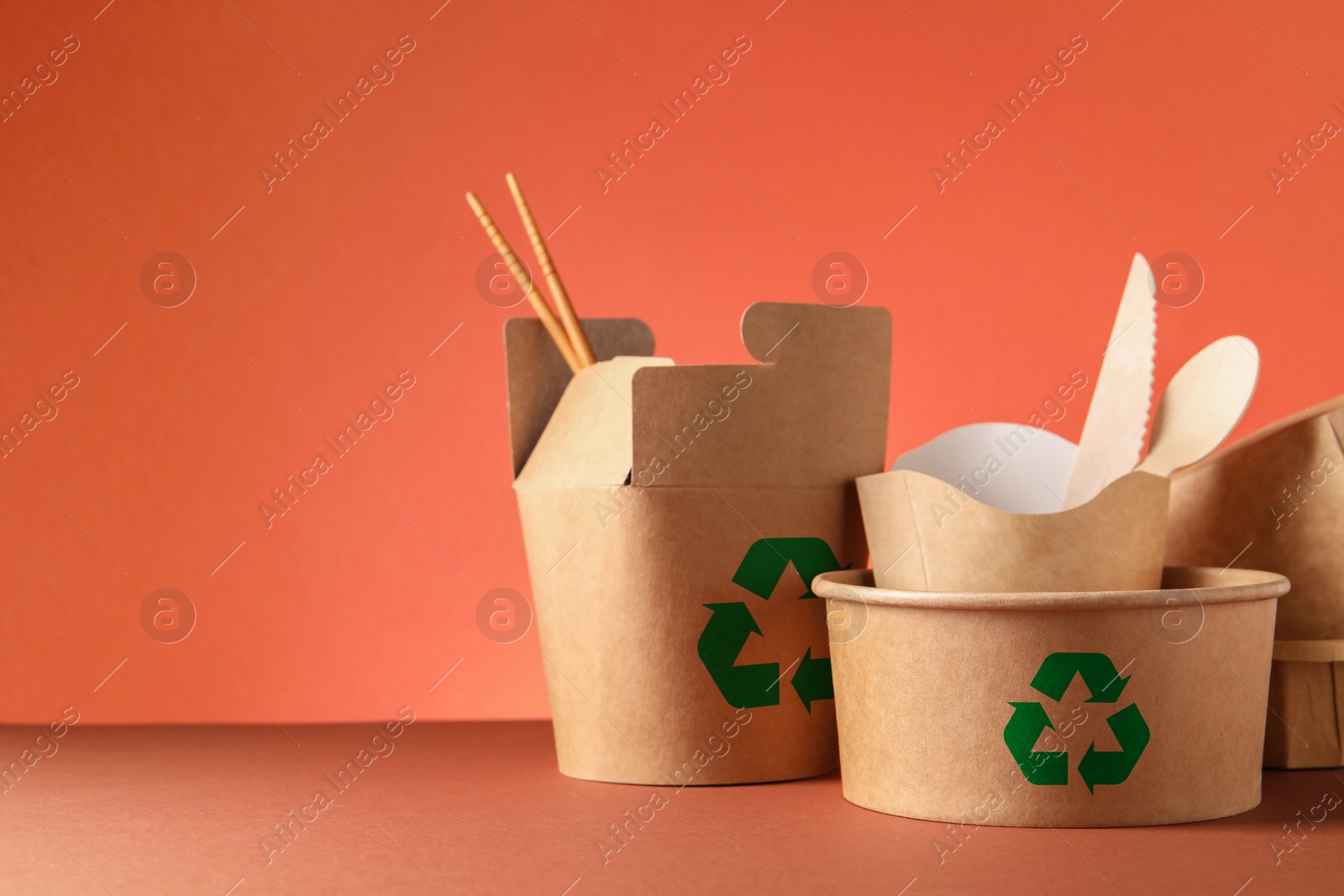 Image of Set of eco friendly food packaging with recycling symbols on coral background. Space for text