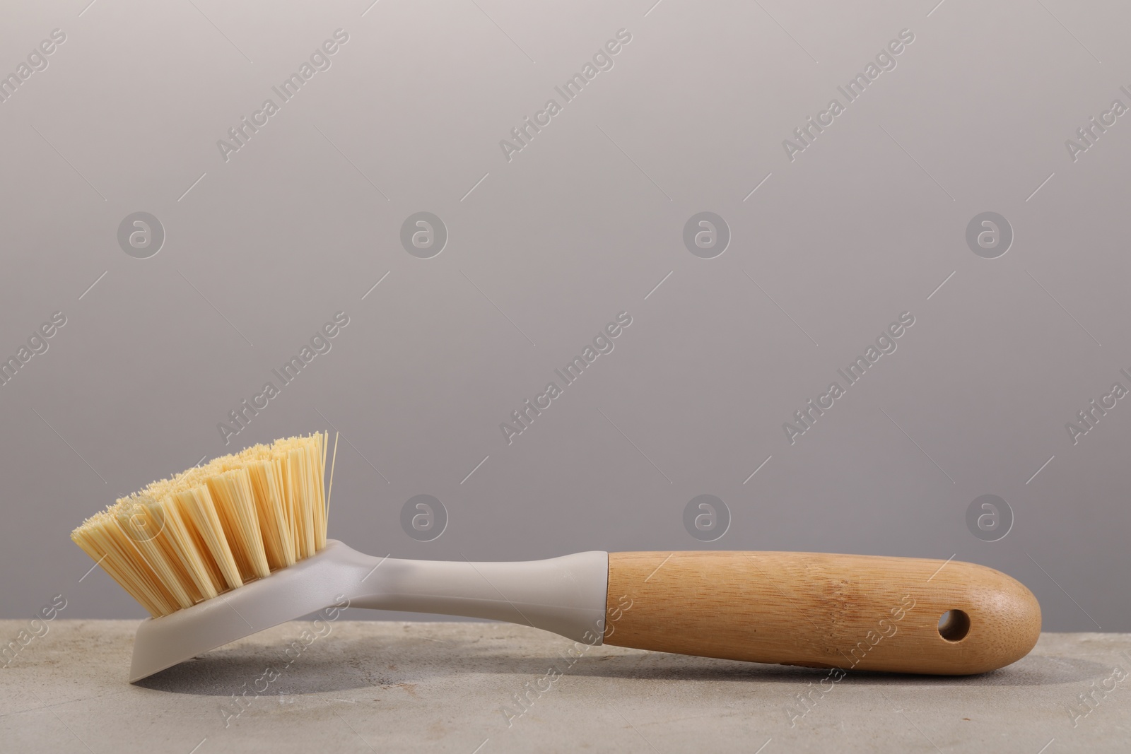 Photo of Cleaning brush on light grey table, space for text