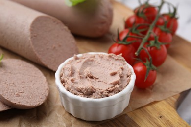 Delicious liver sausages, paste and cherry tomatoes on wooden board, closeup