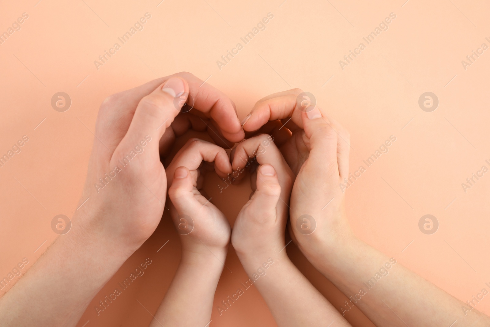 Photo of Happy family holding hands on beige background, top view