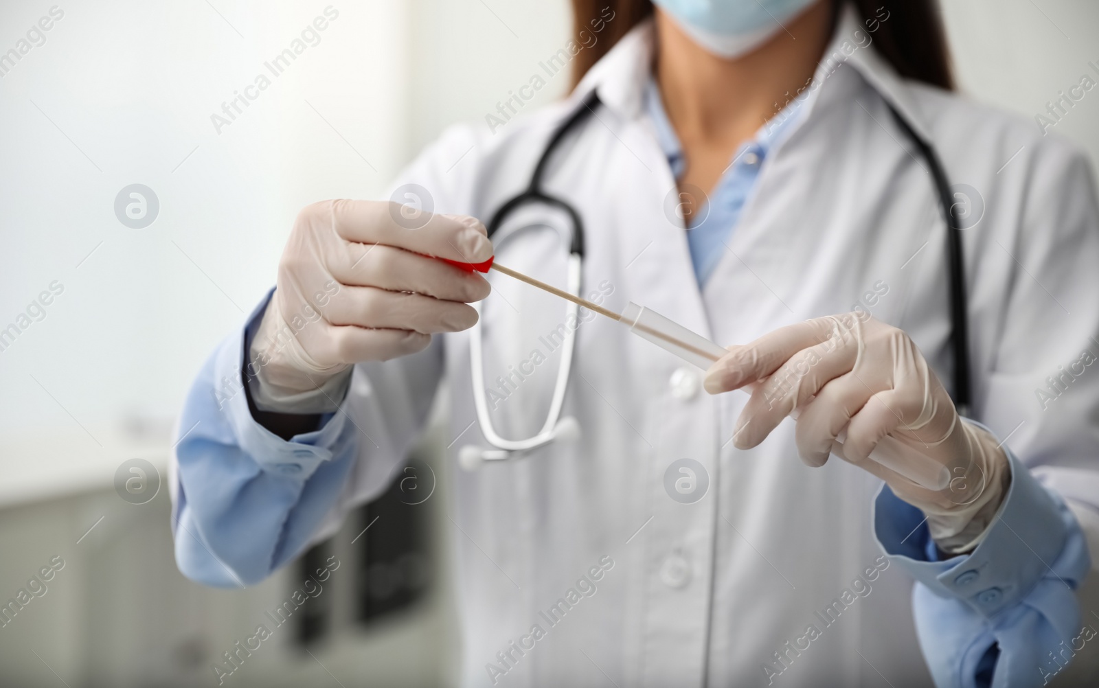 Photo of Doctor holding buccal cotton swab and tube for DNA test in clinic, closeup