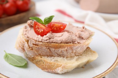 Photo of Delicious liverwurst sandwich with tomatoes and basil on table, closeup