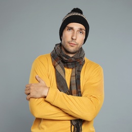 Photo of Handsome young man in warm clothes on grey background. Winter season