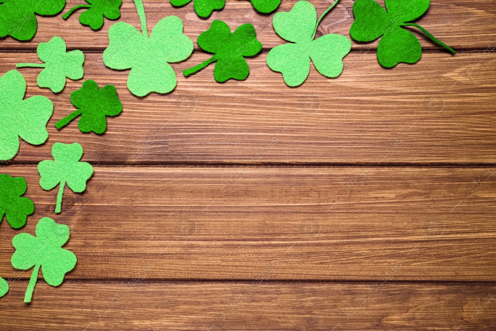 Photo of Flat lay composition with clover leaves on wooden background, space for text. St. Patrick's Day celebration