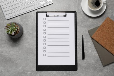 Photo of Clipboard with checkboxes, cup of coffee plant and computer keyboard on grey table, flat lay. Checklist