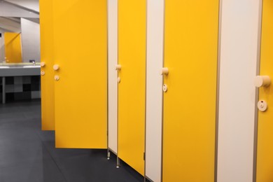 Public toilet interior with bright yellow stalls