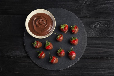 Photo of Flat lay composition with chocolate covered strawberries on wooden background