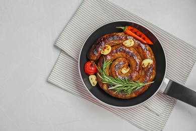 Photo of Delicious homemade sausage with garlic, tomato, rosemary and chili in frying pan on white table, top view. Space for text