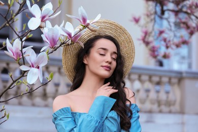 Beautiful woman near blossoming magnolia tree on spring day