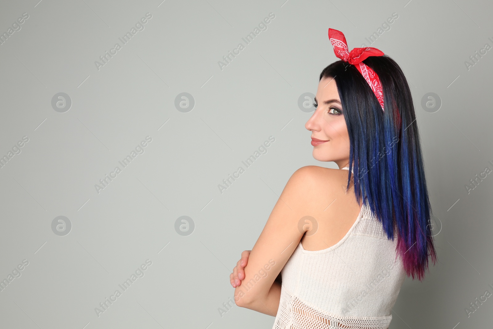 Photo of Young woman with bright dyed hair on light background, space for text