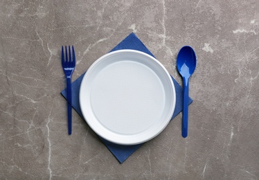 Photo of Composition with plastic dishware on grey background, flat lay. Picnic table setting