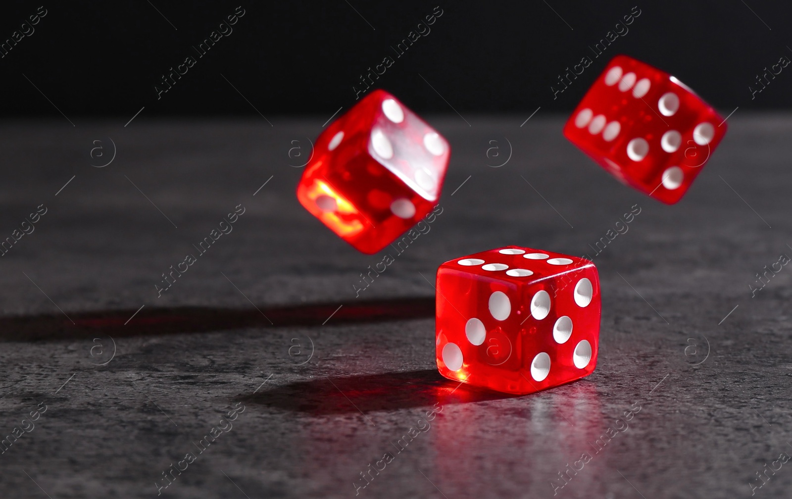Photo of Many red game dices falling on grey textured table