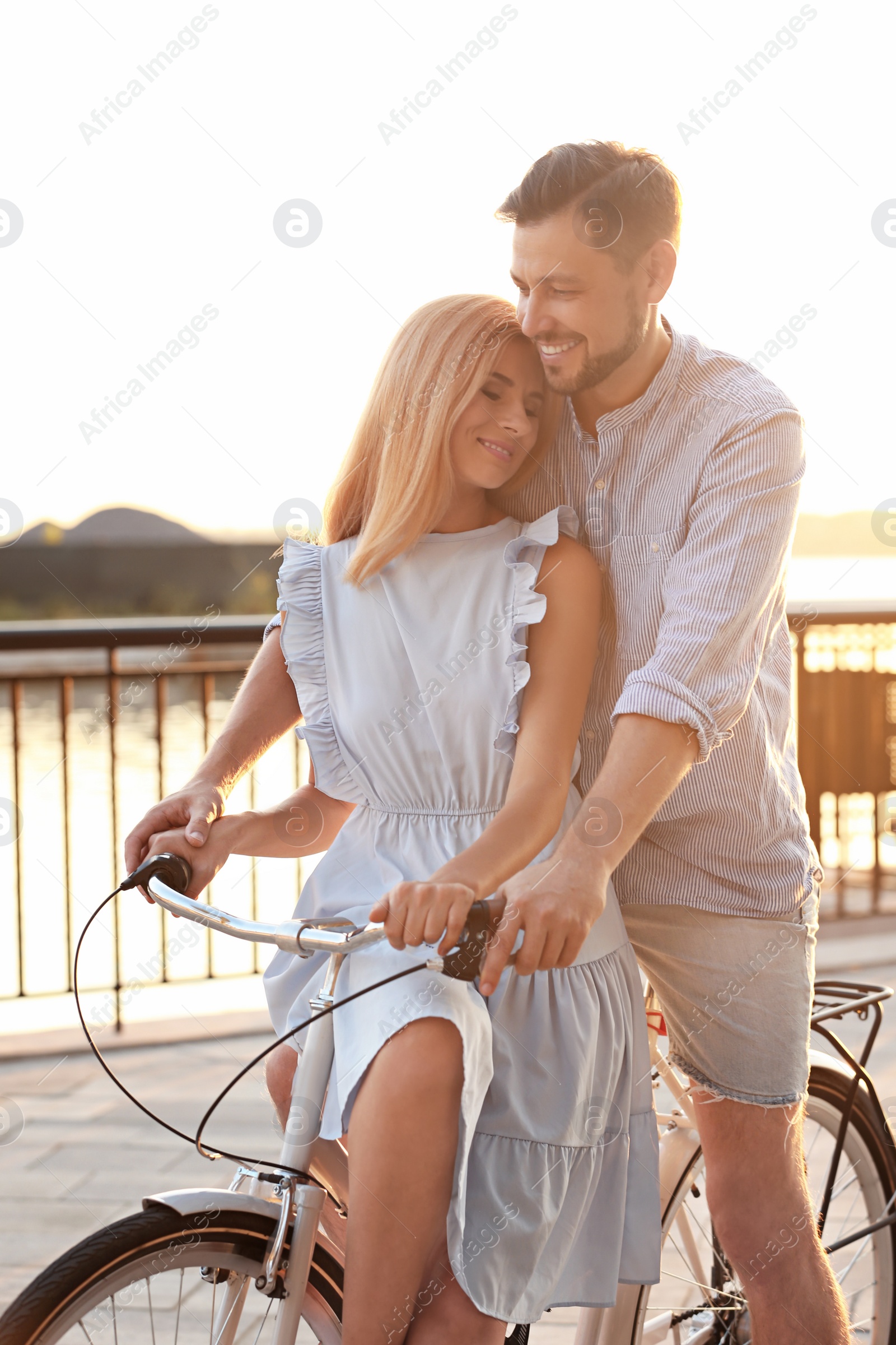 Photo of Happy couple riding bicycle outdoors on summer day