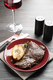 Photo of Delicious roasted beef meat and caramelized pear served on grey wooden table
