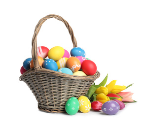 Photo of Basket with colorful Easter eggs and tulips isolated on white