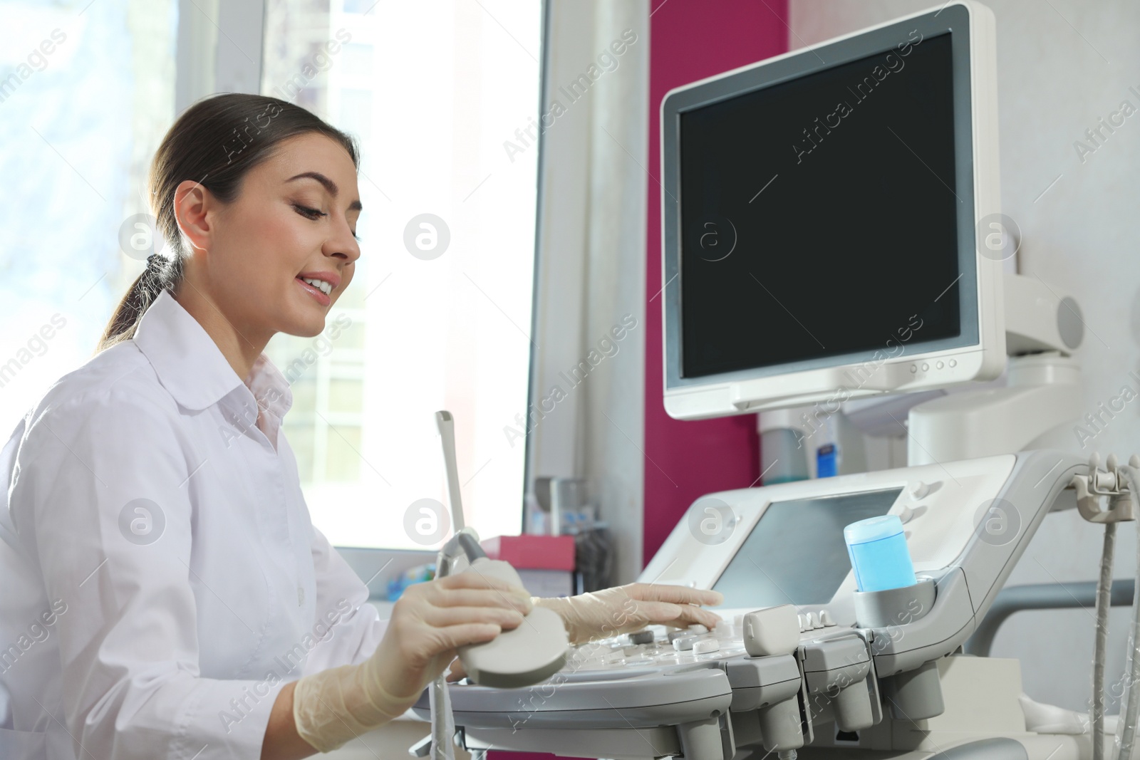 Photo of Sonographer using modern ultrasound machine in clinic