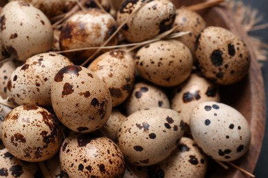 Photo of Many fresh quail eggs in bowl, closeup