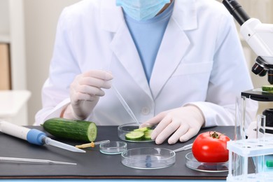 Quality control. Food inspector examining cucumber in laboratory, closeup