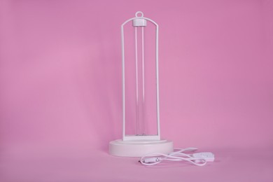 Ultraviolet lamp on pink background. Air sterilization