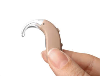 Photo of Woman holding hearing aid on white background, closeup