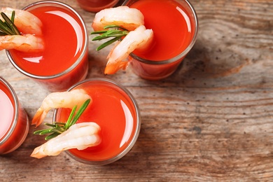 Photo of Delicious shrimp cocktail shots on wooden table