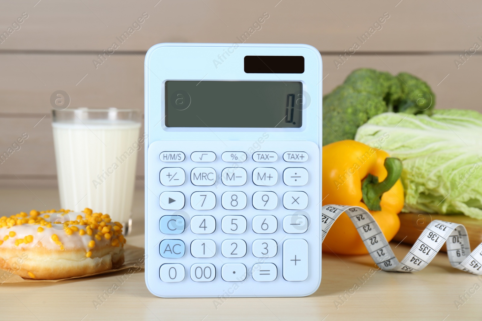 Photo of Calculator and food products on wooden table. Weight loss concept