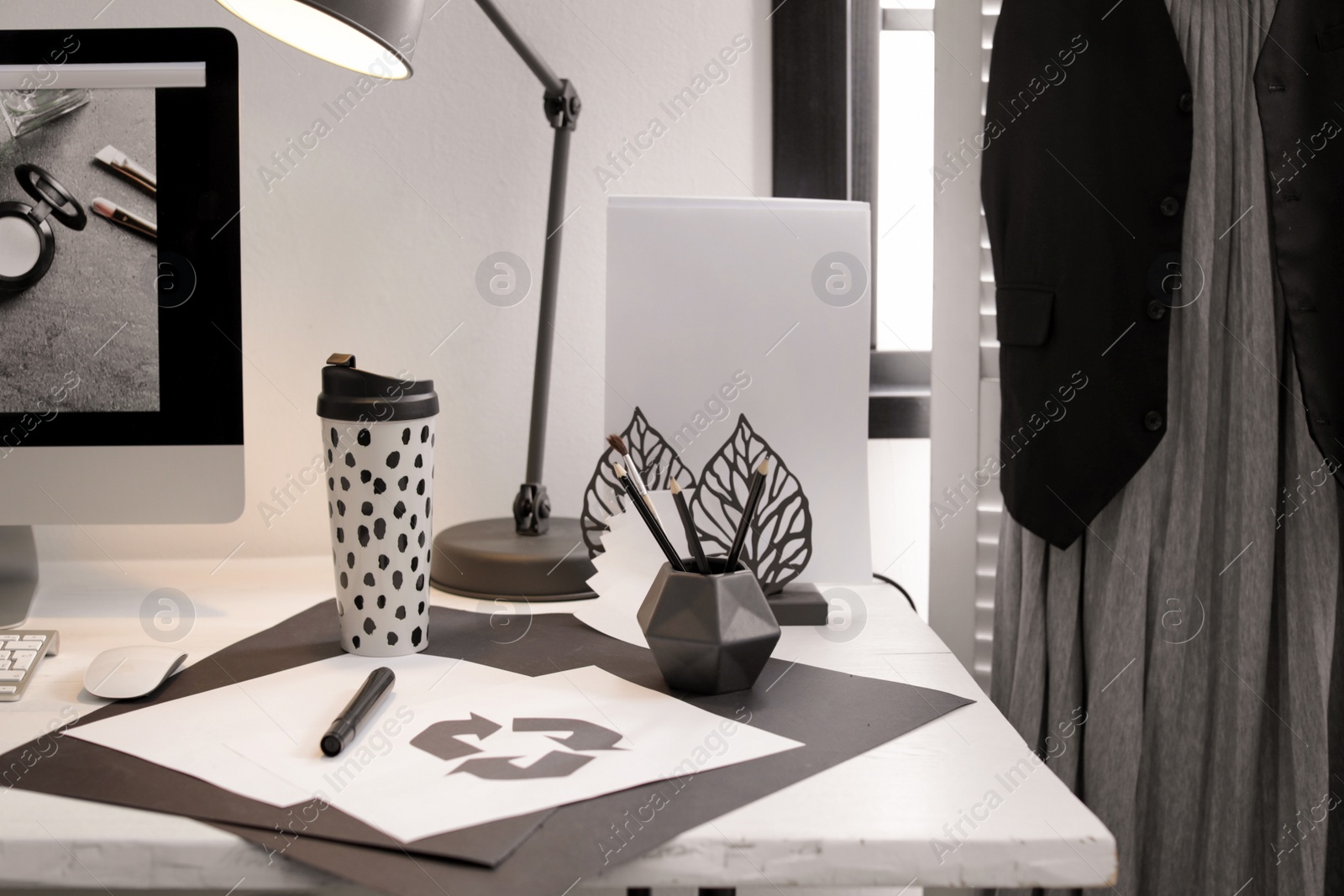 Photo of Stylish workplace with pencil holder and papers on desk