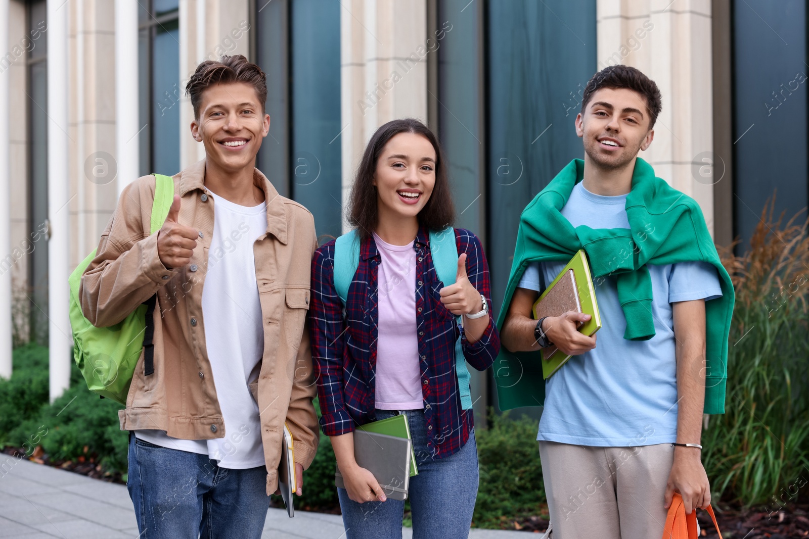 Photo of Happy young students spending time together outdoors