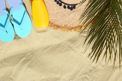Photo of Flat lay composition with beach accessories on sand. Space for text