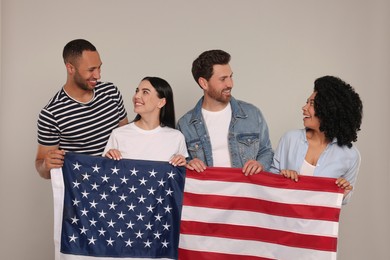 4th of July - Independence Day of USA. Happy friends with American flag on grey background