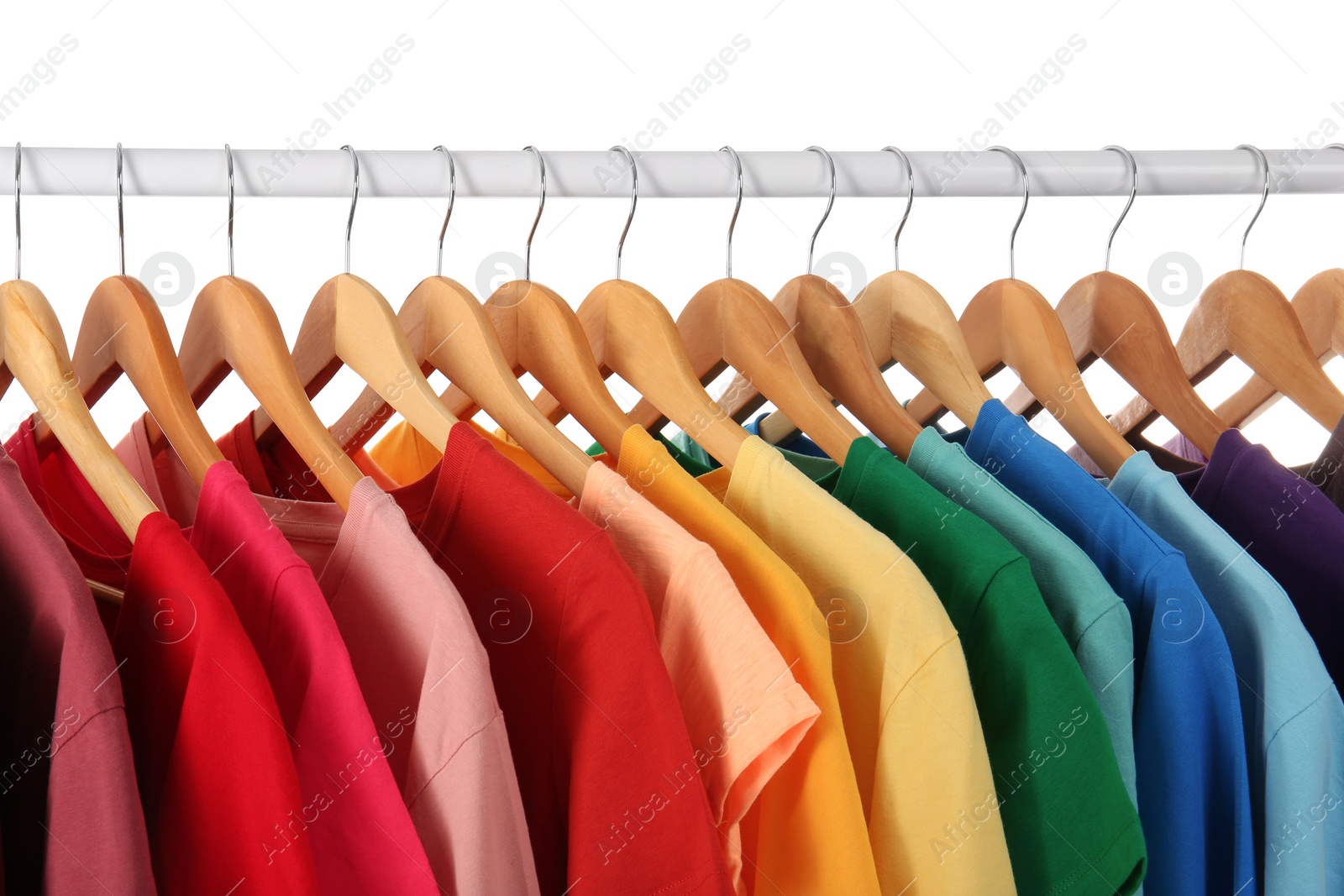 Photo of Many t-shirts hanging in order of rainbow colors, closeup