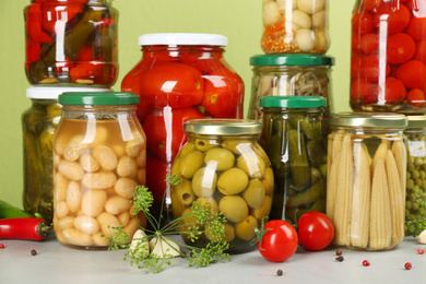 Jars of pickled vegetables and ingredients on light table