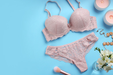 Flat lay composition with sexy women's underwear on light blue background. Space for text