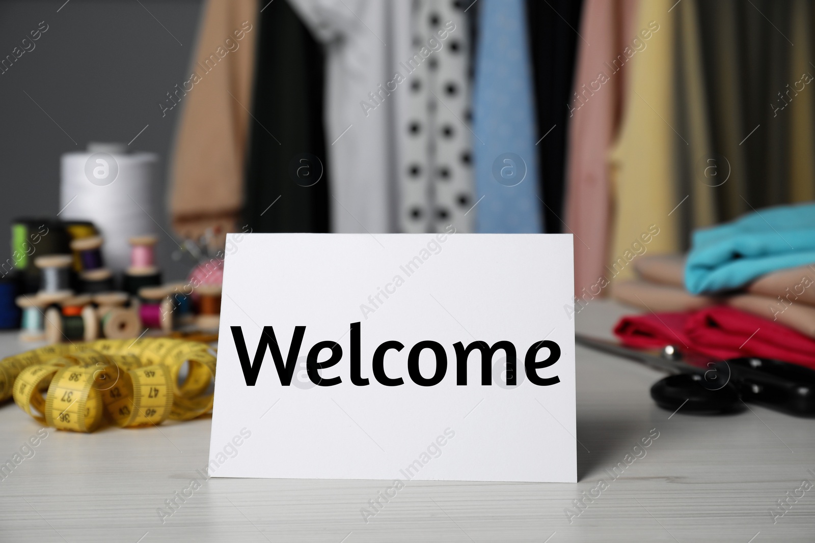 Image of Notebook with phrase Welcome Back and sewing accessories on table