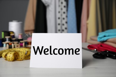 Image of Notebook with phrase Welcome Back and sewing accessories on table