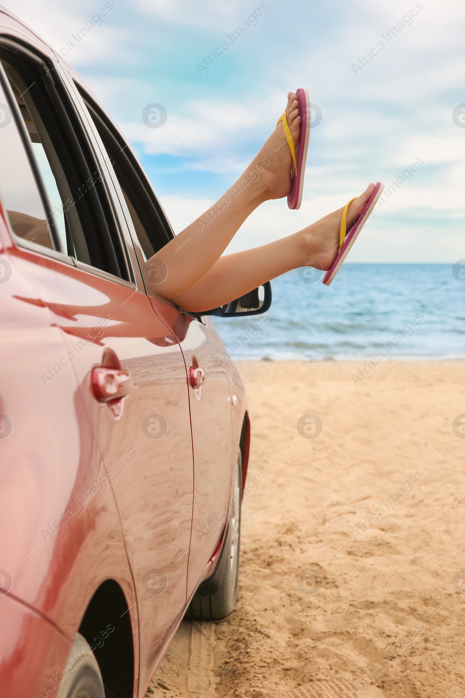 Photo of Woman showing legs from car, closeup. Summer vacation trip